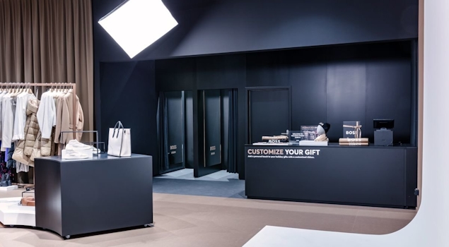 The BOSS Studio in Zurich embodies an avant-garde retail concept within a 250-square-meter space. With a nod to the brand's essence, a vibrant customisation corner and captivating window displays adorned with flashlights enchant passersby. Retail design by Studio Königshausen.